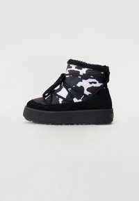 Botín de tobillo en camuflaje blanco y negro, con una suela negra texturizada y forro de piel de imitación, y cordones negros entrelazados en la parte superior.