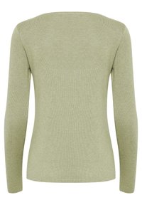 Haut à manches longues en maille côtelée vert clair, avec un col rond et une silhouette ajustée, présentant une texture subtile.