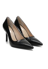 Des escarpins en cuir verni noir avec un bout pointu, un talon fin et une texture lisse. L'intérieur est doté d'une doublure beige.