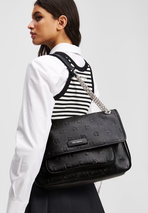 Borsa a tracolla in pelle nera con effetto goffrato, chiusura a ribalta, tracolla a catena e un'etichetta con il marchio. Presenta un motivo sottile e un design elegante.