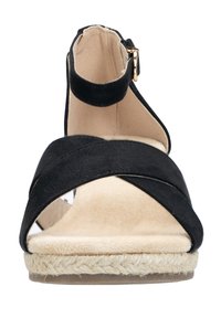 Sandalia de esparto negra de ante con diseño de tiras cruzadas, punta abierta, correa de tobillo con herrajes dorados y suela envolvente de yute. Forro interior beige.
