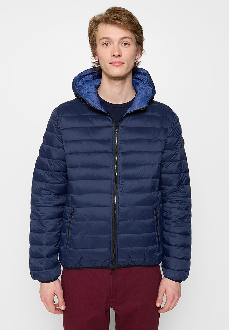 Chaqueta acolchada azul marino con cierre frontal, puños de canalé y capucha. Presenta un patrón de acolchado horizontal y dos bolsillos laterales.