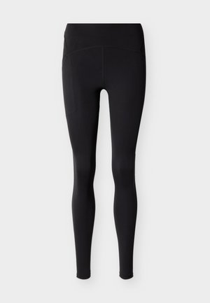 Μαύροι κολάν ψηλόμεσοι και μακριά με λείο, ελαστικό ύφασμα και επίπεδες ραφές, εμφανίζονται μπροστά σε απλό ανοιχτό φόντο.