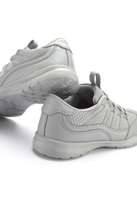 Graue Sportschuhe mit einem Mesh-Obermaterial und genähten Akzenten, runder Zehenpartie, Griffschlaufe und hexagonal gemusterten Sohlen.