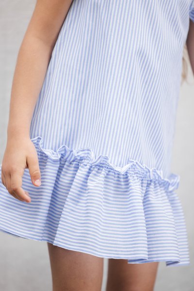 Φόρεμα με ανοιχτό μπλε και λευκές ρίγες, με βολάν στο τελείωμα, κοντά μανίκια και άνετη εφαρμογή. Μαλακό βαμβακερό ύφασμα.