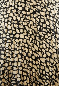 Tessuto plissettato con motivo leopardato in toni di nero e beige. Texture liscia, con forti contrasti di colore e linee verticali.