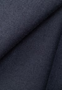 Tela texturizada azul oscuro con un patrón acanalado, que muestra un acabado suave y un brillo sutil. El material parece duradero y flexible.