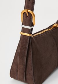 Borsa a tracolla in suede marrone con un design elegante, una fibbia in metallo dorato e una chiusura con zip nella parte superiore per una conservazione sicura.