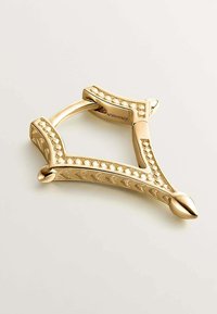 Accesorio metálico en tono dorado con forma de triángulo, que presenta patrones decorativos y acentos suaves con un acabado pulido.