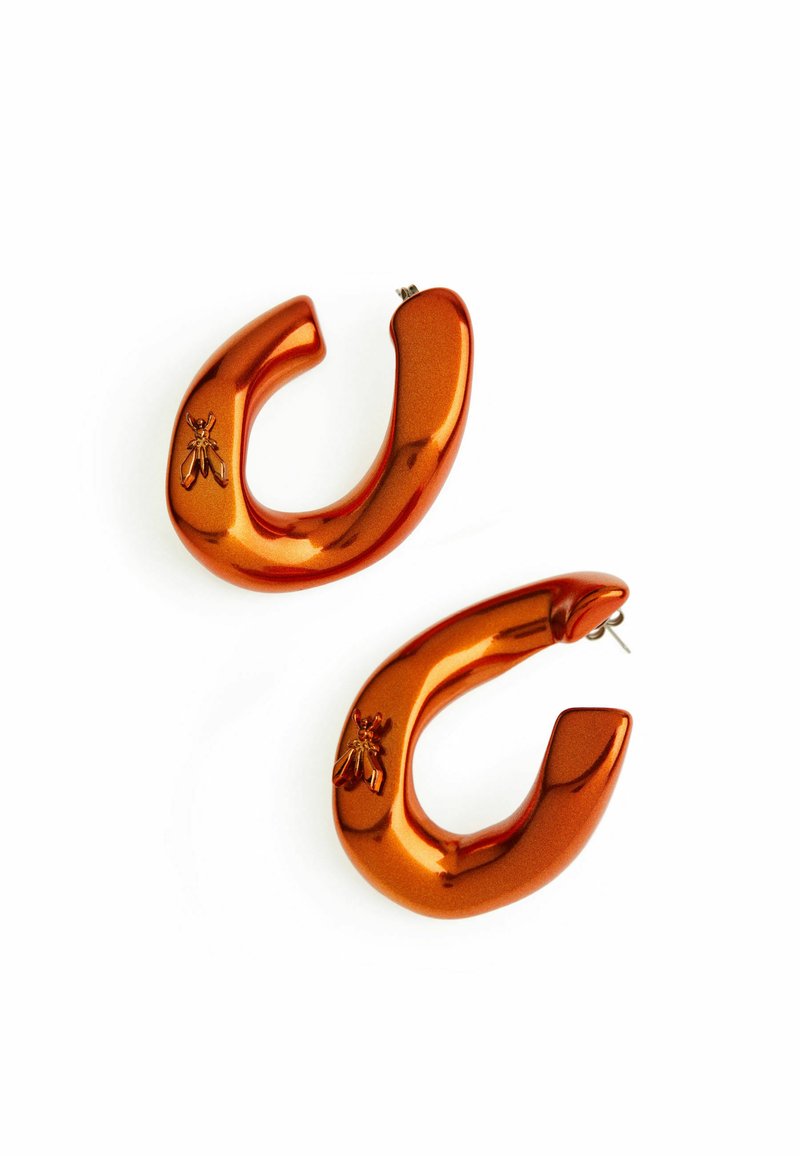Orecchini a cerchio metallici arancioni con una forma curva e una finitura lucida. Ogni orecchino presenta un dettaglio a rilievo a forma di ape.