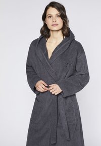 Graue, strukturierte Frottee-Badejacke mit Kapuze, Bindegurt und aufgesetzten Taschen. Mit gesticktem Detail auf der Brust.