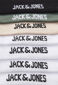 Cinco pares de calcetines apilados en negro, oliva, beige y blanco, cada uno con "JACK & JONES" bordado en negro en los puños.