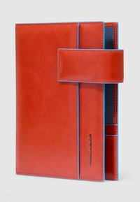 Rode leren portemonnee met blauwe accenten, voorzien van een magnetische sluiting en binnenvakken voor organisatie. Gladde textuur en rechthoekige vorm.