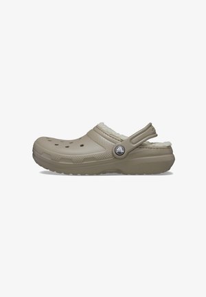 Sabot beige en caoutchouc avec une douce doublure en fausse fourrure blanche, des trous de ventilation sur le dessus et une sangle latérale pour un ajustement sécurisé.