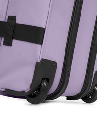 Fialový taškový kufr s texturovaným povrchem, černými akcenty, dvojitými kolečky a pevným popruhem pro snadnou mobilitu a manipulaci.