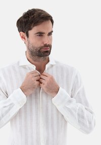 Camicia a maniche lunghe in lino bianco e leggero, con righe verticali, colletto con bottoni e polsini con bottoni, caratterizzata da una vestibilità comoda e da una texture morbida.