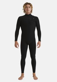 Black wetsuit with long sleeves, featuring shoulder zip, textured knee pads, snug fit, and minimal seams for reduced water entry.