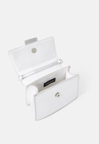 White faux leather wallet with a snap closure. Interior features a fabric lining and a label. Smooth texture, rectangular shape, minimal design.