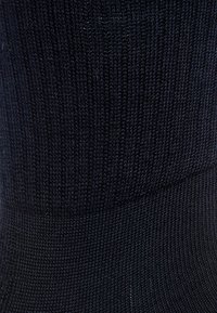 Tejido de punto negro con una fina textura acanalada y un ligero brillo. El material parece elástico y ajustado, sin patrones visibles.