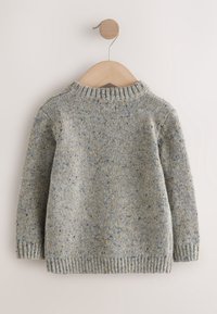 Pull en maille gris avec des taches bleu et jaune, suspendu sur un cintre en bois clair sur un fond clair.