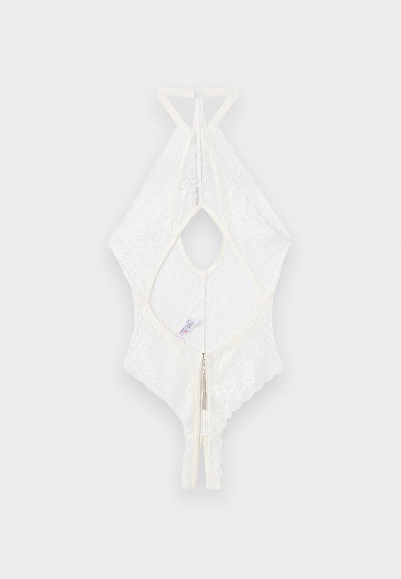 Λευκό κορμάκι με δαντέλα, σχέδιο halter neck, φερμουάρ στο πίσω μέρος και ανοιχτό σχέδιο με άνοιγμα σαν κλειδί, τοποθετημένο επίπεδα σε ανοιχτό γκρι φόντο.