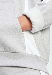 Grå hettegenser med en myk tekstur, hvite sidelister, en koselig mansjett og en frontlomme, som viser en avslappet design.