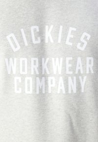 Felpa grigia in cotone con grande testo bianco che recita "DICKIES WORKWEAR COMPANY", uniformemente spaziato e centrato.