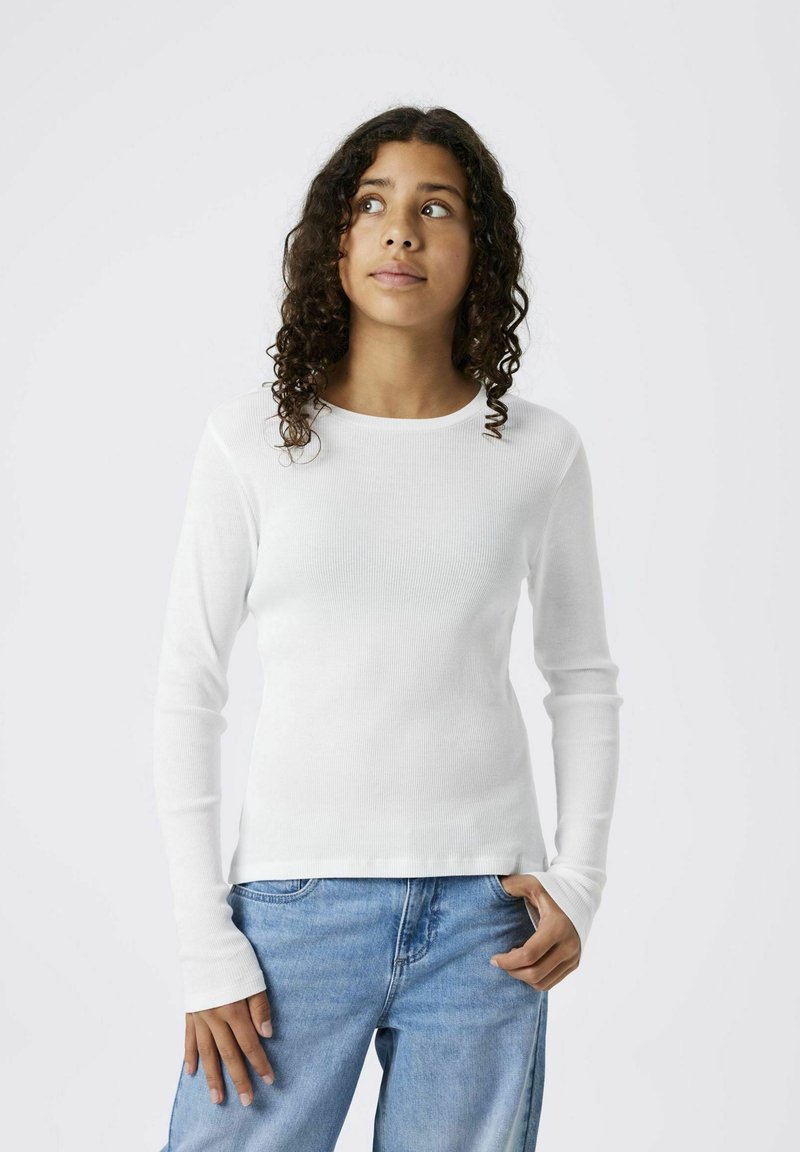 Weißes langärmeliges Rippoberteil mit Rundhalsausschnitt und figurbetonter Silhouette, kombiniert mit hellblauen Jeans. Glatte Textur und minimalistisches Design.