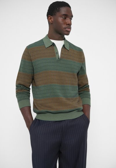 Adīts džemperis ar zaļām, brūnām un zelta horizontālām svītrām. Aprīkots ar apkakli un trīs pogu aizdari, ribotām aprocēm un apakšmalu.