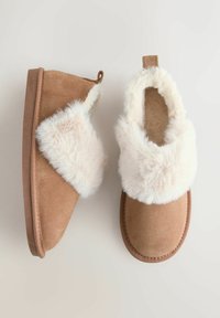 Brown suede slippers with thick white faux fur lining, shown from side and top views on a light background.