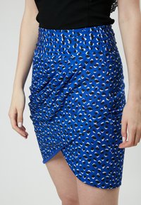 Blauwe dierenprint rok met een geplooid ontwerp. Gemaakt van een gladde stof, met een hoge taille en een asymmetrische zoom.