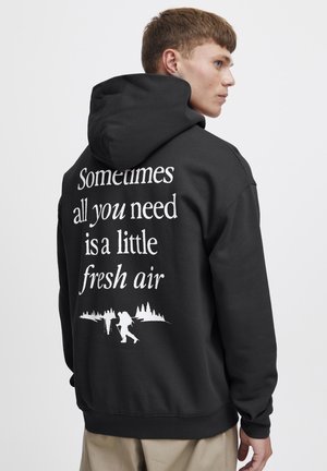 Sort hoodie med et grafik på ryggen, som viser hvid tekst og en illustration af vandrere mod en skovsilhuet.