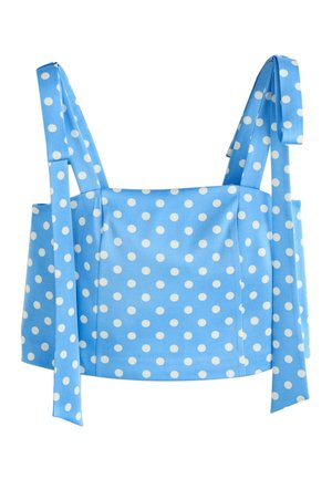 Top albastru scurt cu buline albe, cu bretele late legate în funde.