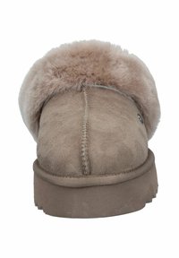 Tan suede slipper with a fluffy beige fur collar, flat sole, and decorative stitching along the seam. Simple and comfortable design.