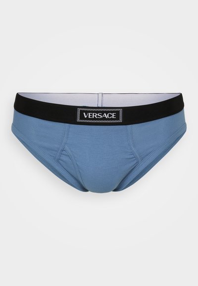 Culotte en coton bleu avec une texture côtelée, dotée d'une taille élastique noire estampillée "VERSACE". Conception de poche avant pour un soutien et une couverture.