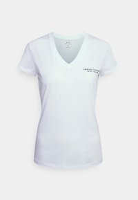 White short-sleeve T-shirt with a V-neck, made of cotton. Features blue "Armani Exchange" logo printed on the left chest. Simple design.