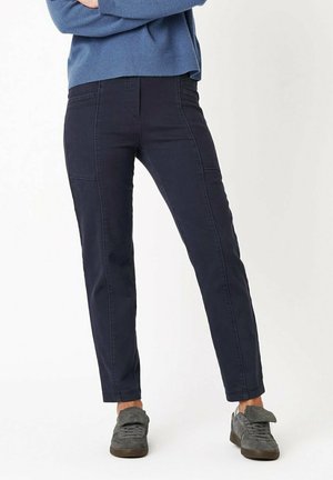 Navy blue cotton blend pants with a slim fit, featuring side pockets and tonal stitching. Paired with gray sneakers and blue sweater.