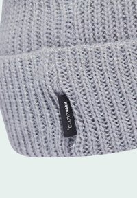 Graue gestrickte Mütze mit gerippter Textur und sichtbaren Nähten. Besitzt ein schwarzes Etikett mit der Aufschrift "CLIMAWARM". Weiches, warmes Material.