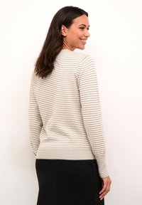 Pull en tricot beige et gris rayé avec un col arrondi et des poignets côtelés, présenté sur un fond blanc uni.