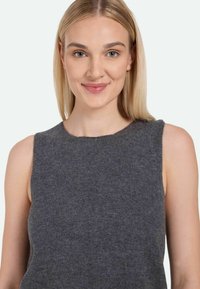 Gray sleeveless knit top made from a soft, textured fabric. Features a round neckline and a relaxed fit, suitable for layering.