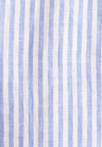 Tissu blanc avec des rayures verticales bleu clair régulièrement espacées et une texture tissée.