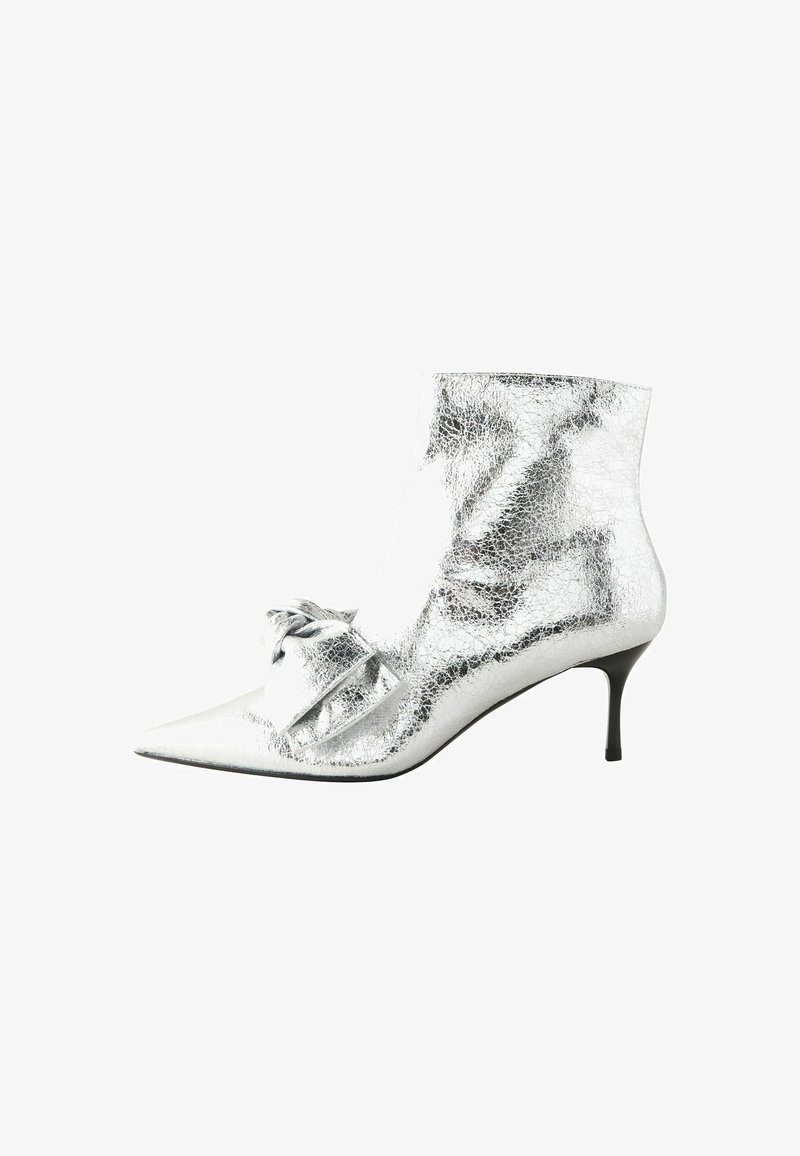Bottines argentées avec une texture métallique craquelée, bout pointu, petit talon aiguille et un accent noué sur le côté.