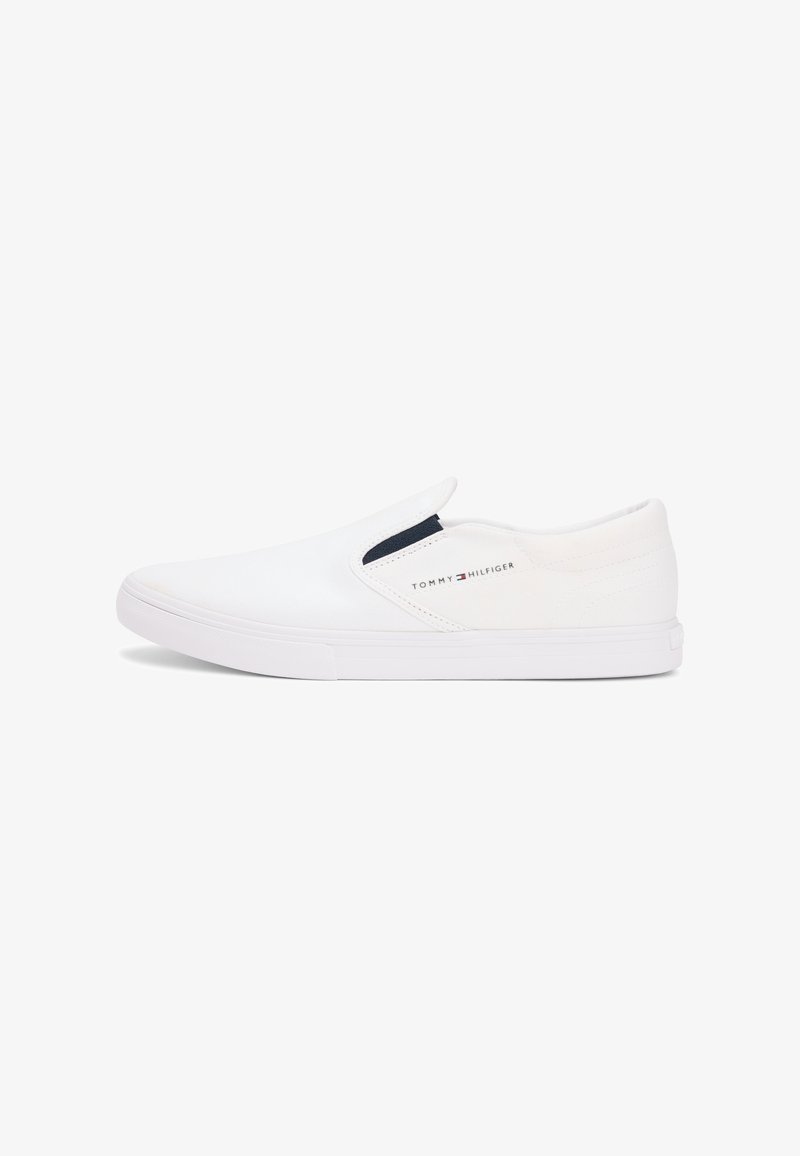 Baskets blanches à enfiler avec un panneau latéral élastique, une semelle basse et le logo Tommy Hilfiger sur le côté droit.