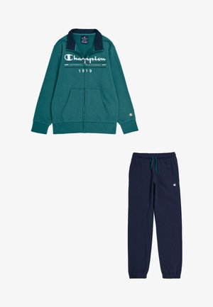 Giacca teal con zip, polsini a coste e collo blu navy, abbinata a pantaloni jogger blu navy scuri con vita elasticizzata e dettagli con logo.