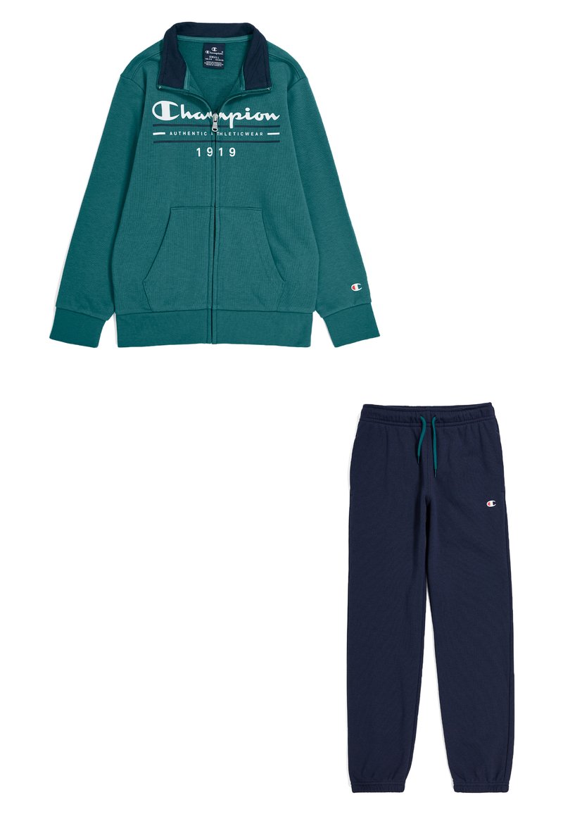 Giacca teal con zip, polsini a coste e collo blu navy, abbinata a pantaloni jogger blu navy scuri con vita elasticizzata e dettagli con logo.