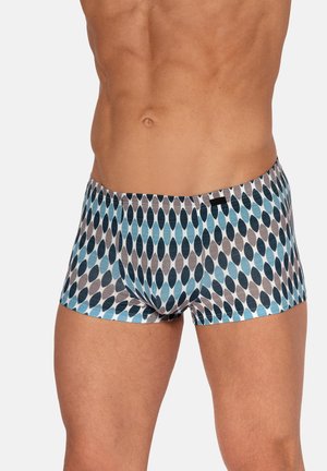 Torso masculin portant un boxer ajusté avec un motif ovale abstrait dans des tons de bleu et de gris sur fond blanc.