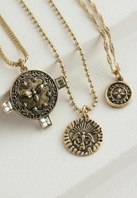 Trei coliere metalice aurii: unul cu un pandantiv în formă de albină și strasuri, altul cu un design de leu și un pandantiv circular cu un motiv floral.