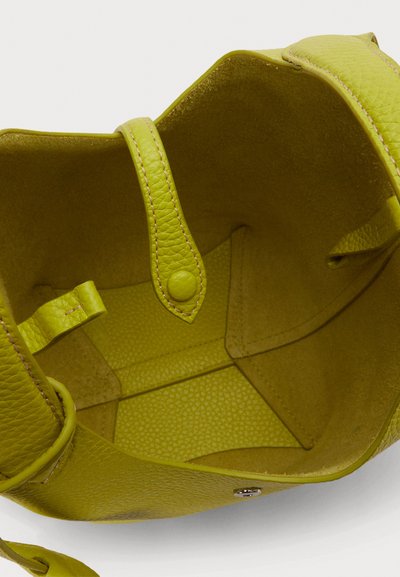 Torba za nošenje od limete zelene kože s teksturiranim završetkom. Ima dva čvrsta ručka, unutarnje džepove i zatvaranje na kopču.