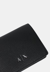 Portafoglio nero texture con finitura liscia. Presenta un logo metallico "A/X" sul davanti. Forma rettangolare compatta, senza accentuazioni visibili.