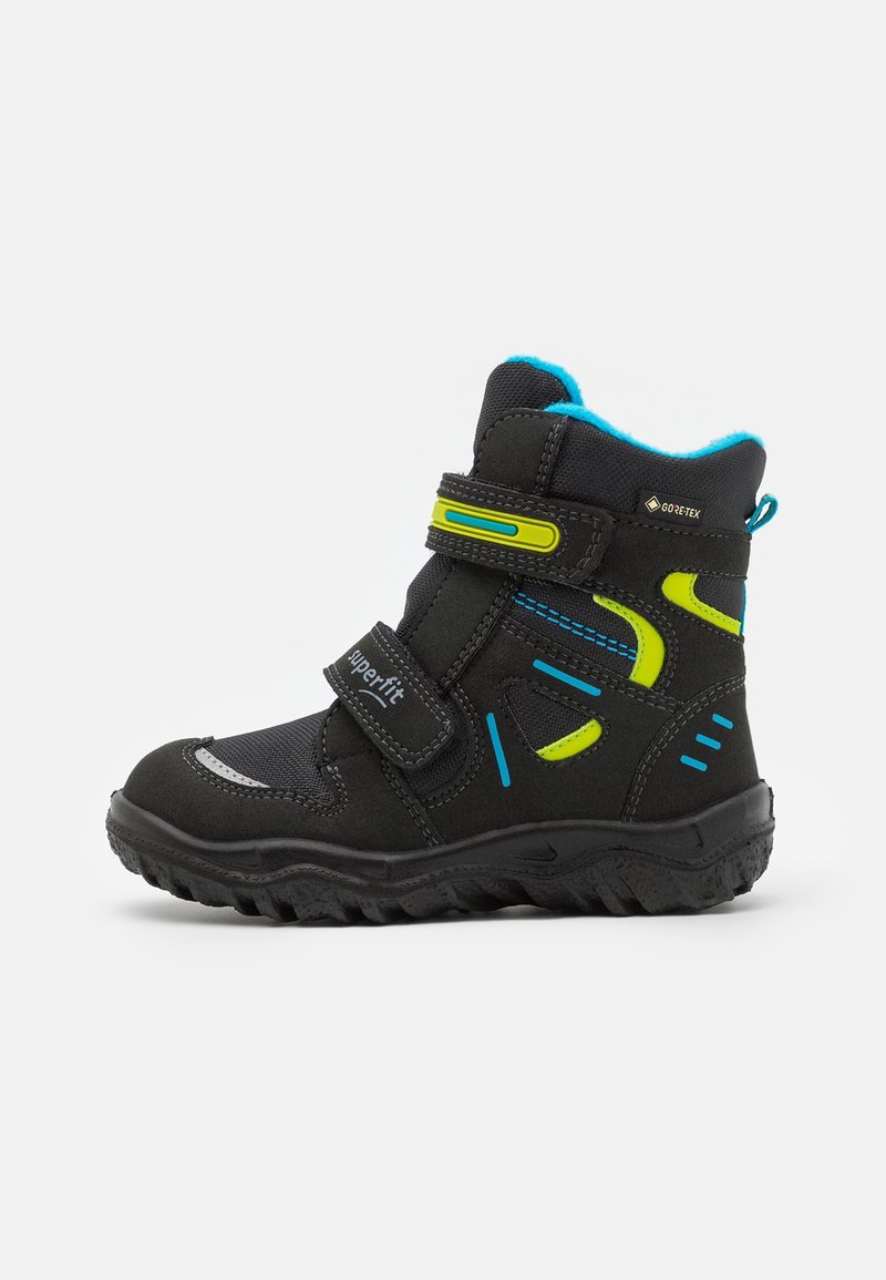 Botte d'hiver pour enfants noire avec accents bleus et jaunes, double bande Velcro, semelle robuste et matériau imperméable Gore-Tex.